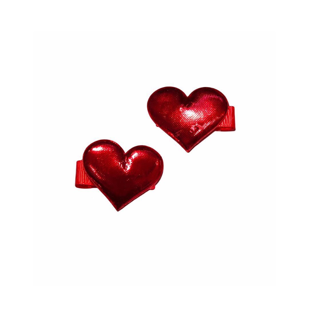 Pair of high-shine metallic red padded heart-shaped hair clips for children on a white background.