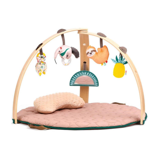 Neutral-toned baby playmat with natural wooden arches and hanging sensory toys like a mirror and rattle.
