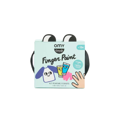 Hand holding a box of Omy finger paint with four tubes of colorful paint on a purple background. Lebanon