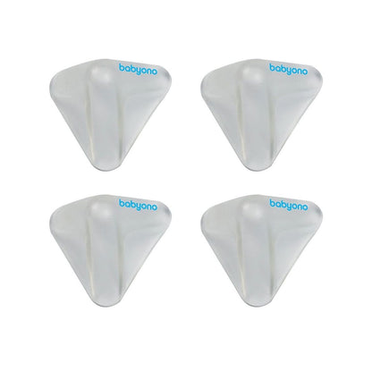 Pack of Babyono clear silicone corner protectors installed on the edge of a wooden table.