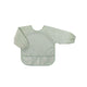 An olive green long-sleeved waterproof bib apron for babies by Trois Kilos Sept, featuring a front pocket for catching food.