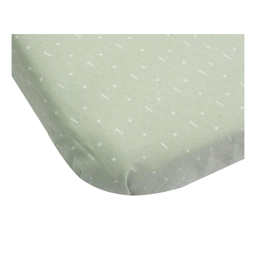 A set of two 100% cotton fitted sheets for a baby crib by Trois Kilos Sept, featuring one solid olive green and one geometric print.