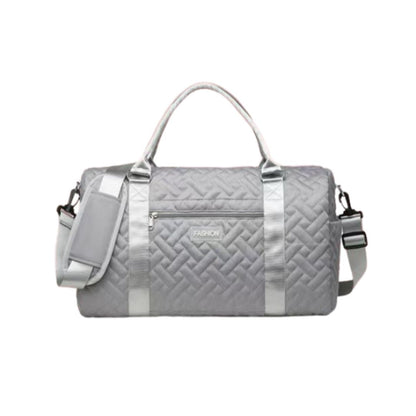 Gray quilted duffel bag with silver accents on a white background