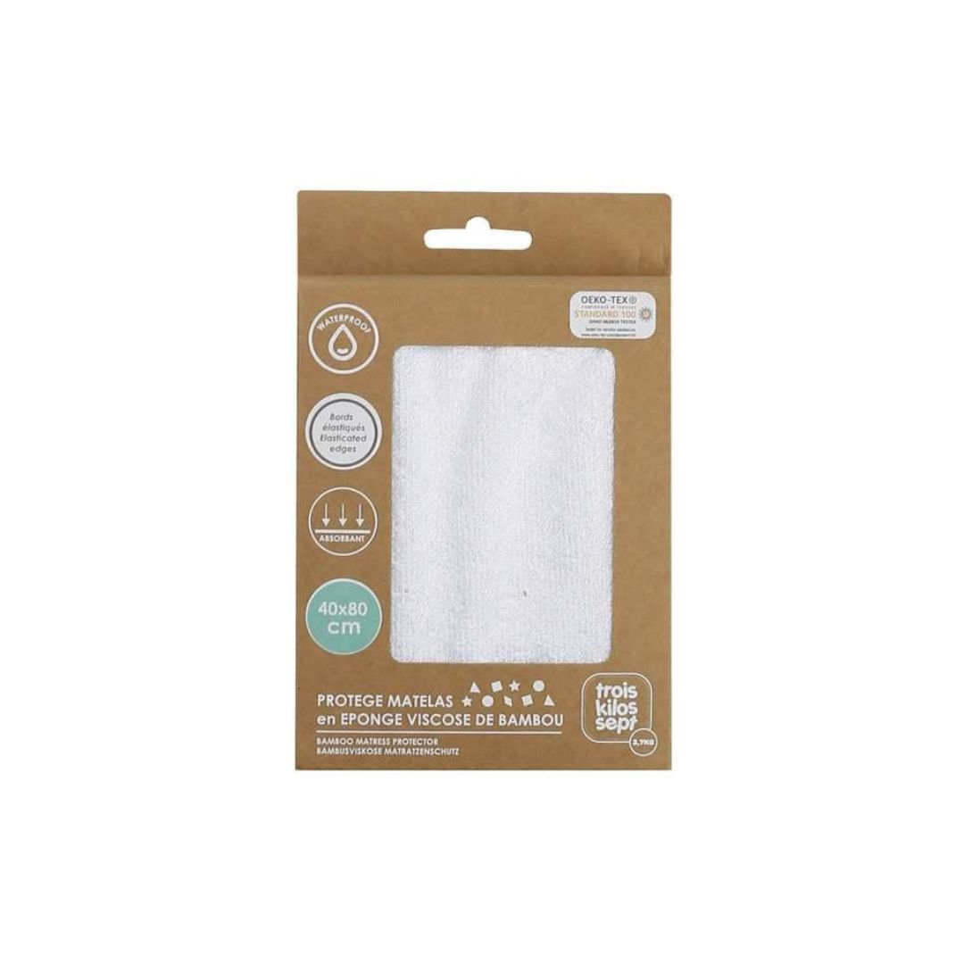Packaging of a mattress protector with a white fabric sample on a brown background