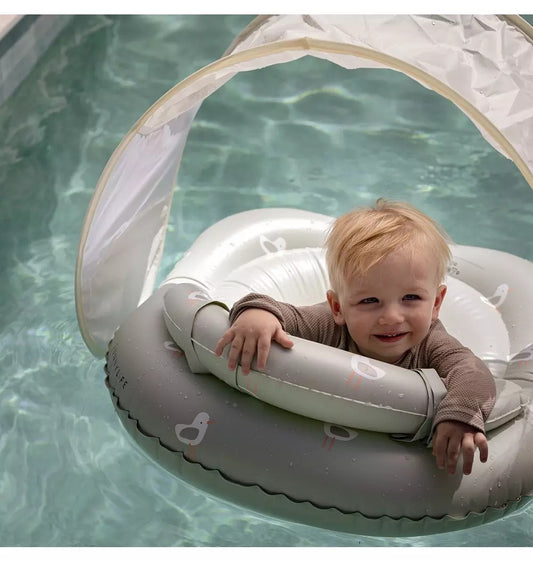 A vibrant, high-quality white inflatable infant pool float styled as a friendly seagull character with built-in toys and a matching protective sun canopy.